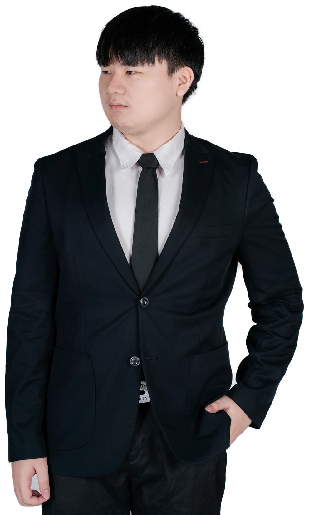 Yan in a black suit and tie, looking to the side